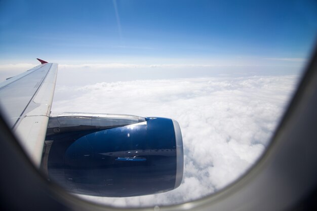 Looking to airplane engine through the window during flight from inside of plane