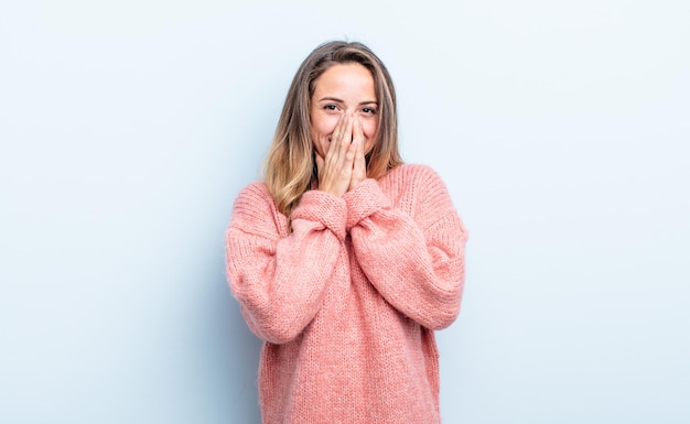 Looking happy cheerful lucky and surprised covering mouth with both hands