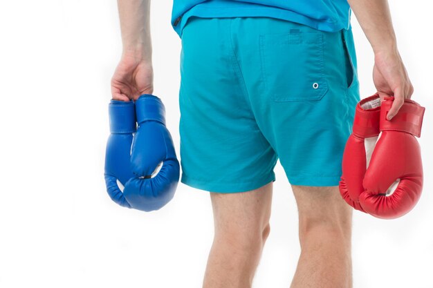 Looking for opponent. Man in shorts carries two pairs boxing gloves rear view isolated white background. Equipment professional sportsman. Professional equipment boxing. Boxing gloves male hand.