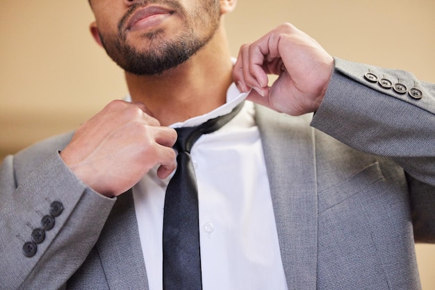 Looking for the right tie to complete the look Low angle shot of an unrecognizable young man putting on a tie in his bedroom at home