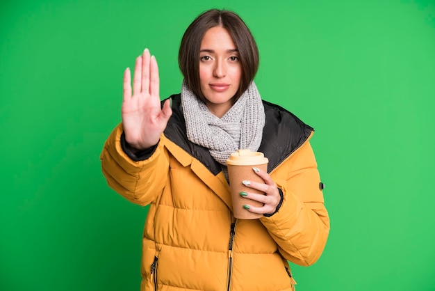 Looking serious showing open palm making stop gesture