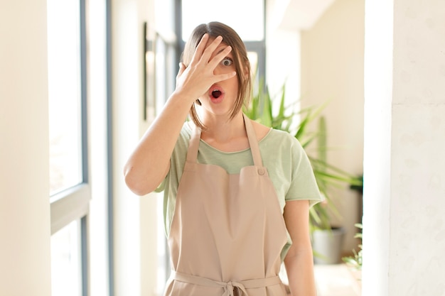 looking shocked, scared or terrified, covering face with hand and peeking between fingers