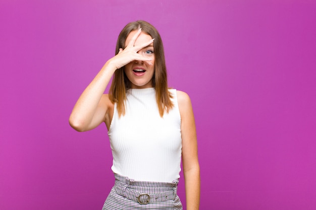 looking shocked, scared or terrified, covering face with hand and peeking between fingers