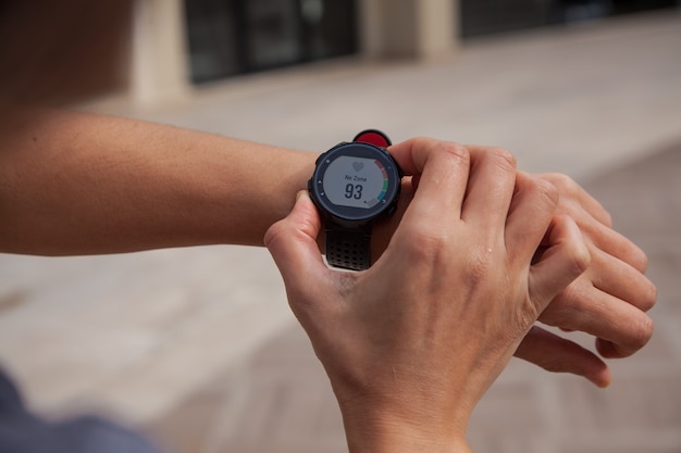 Looking at the smartwatch on the treadmill Running in the gym concept Active lifestyle cocept