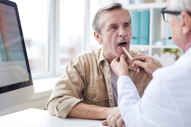 Looking at throat of senior patient