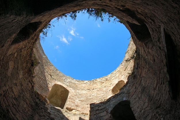 Looking through hole of a ancient tower at blue sky