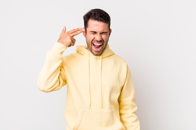 Looking unhappy and stressed suicide gesture making gun sign with hand pointing to head