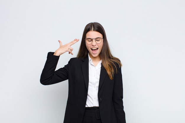 looking unhappy and stressed, suicide gesture making gun sign with hand, pointing to head