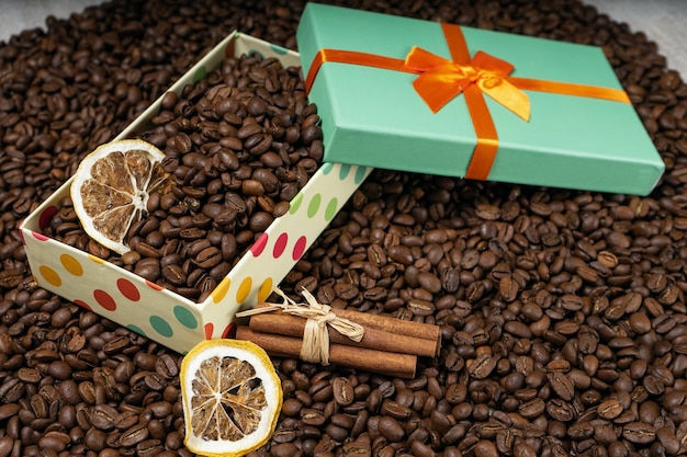 Loose coffee beans, gift box with dried lemon coffee beans and cinnamon sticks.