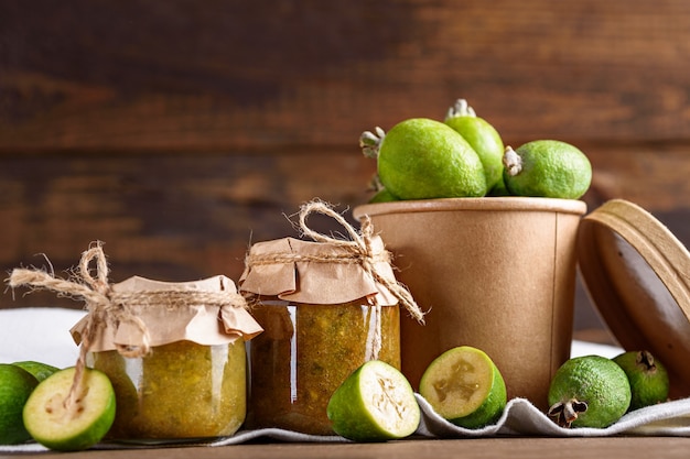 Lose up jars of feijoa jam on brown wooden background