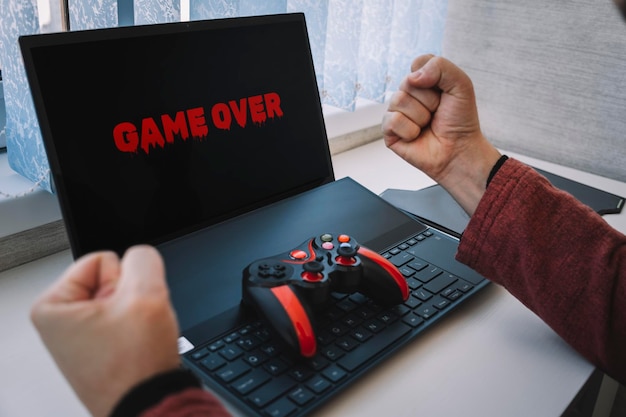 Losing a video game joystick on the keyboard gestures Game over on laptop screen