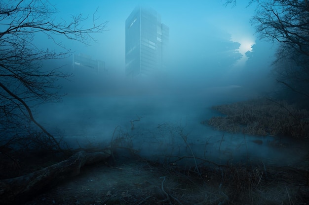 Lost place an abandoned skyscraper stands over a body of water blue fog in the foreground