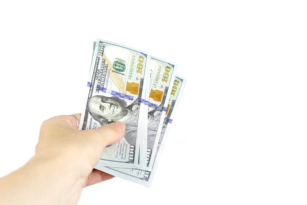 A lot of American currency in a female hand Cropped Hand Of Woman Hold Paper Currencies On White Background