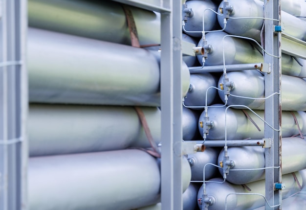 A lot of bottles filled with gas or gasoline are stacked in piles