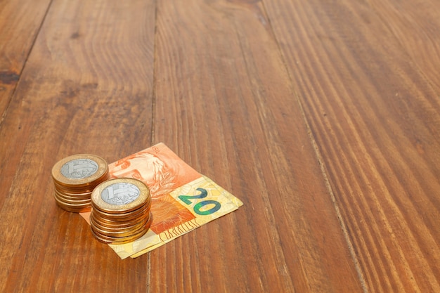 Lot of brazilian coins and bank notes on a wood table