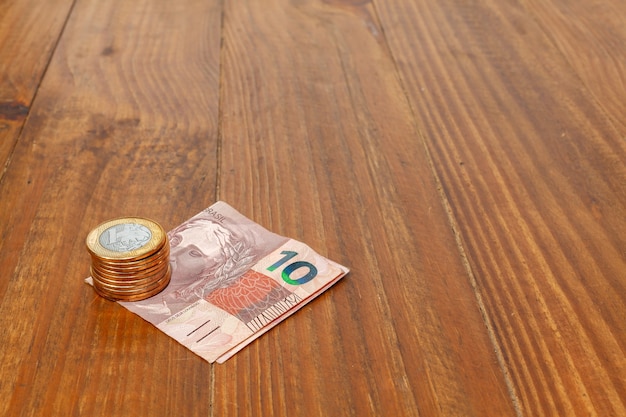 Lot of brazilian coins and bank notes on a wood table