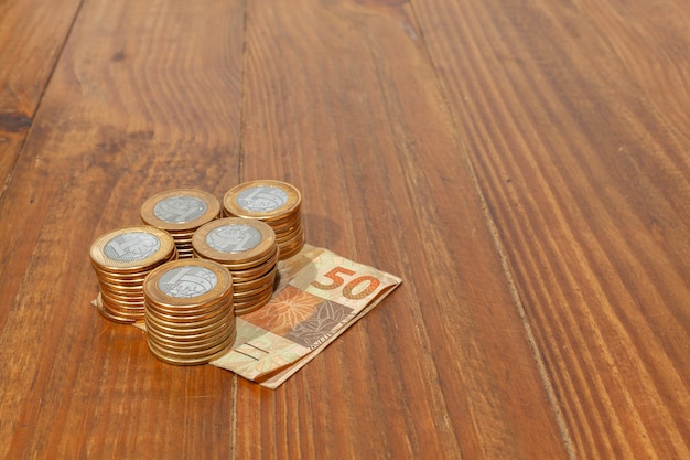 Lot of brazilian coins and bank notes on a wood table