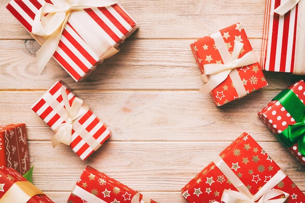 A lot of Christmas gift boxes in colored paper decorated on table Top view close up Many present New Year gift