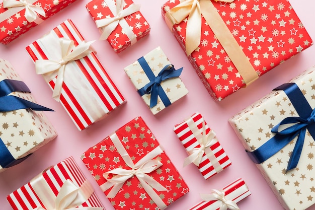 A lot of Christmas gift boxes in colored paper decorated on table Top view close up Many present New Year gift