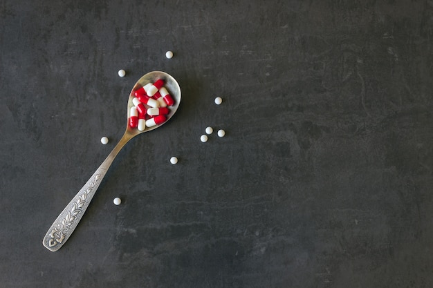 Lot of colored pills and medicines in a spoon