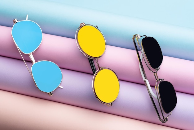 A lot of colorful Fashion Sunglasses put on colorful pastel paper background