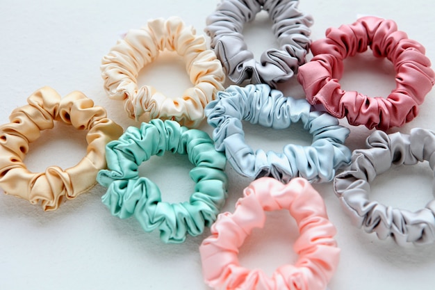 lot of colorful silk scrunchies on white flat layof lastic hairbands scrunchie hairband