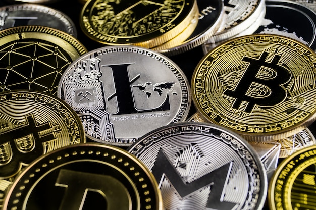 A lot of cryptocurrency coins lie on a dark surface