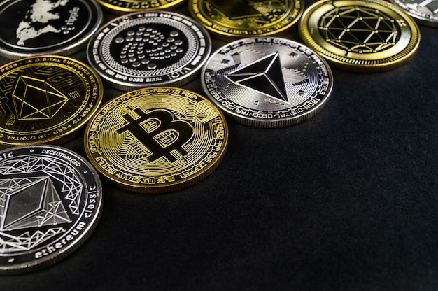 A lot of cryptocurrency coins lie on a dark surface