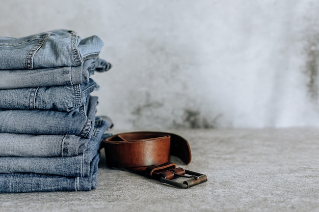 Lot of different blue jeans Blue Jeans, stack of jeans and brown belt.