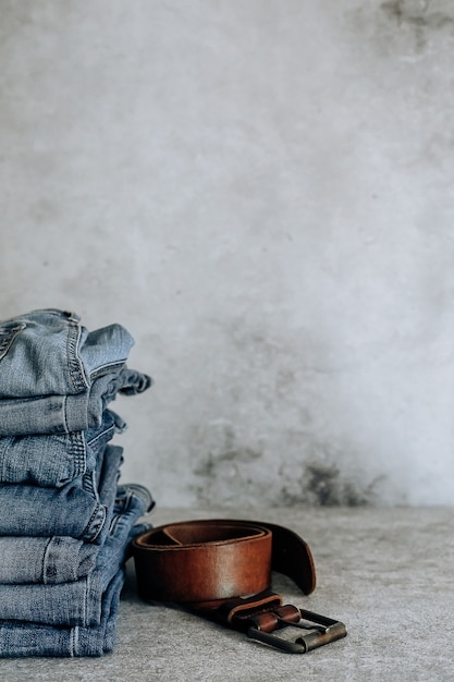 Lot of different blue jeans Blue Jeans, stack of jeans and brown belt.