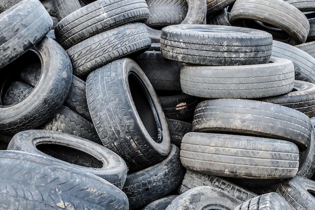 A lot of different old dirty worn out car tires in a landfill Closeup