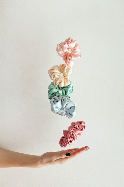 Lot of floating Colorful silk Scrunchies on womas hand Hairdressing tools and accessories