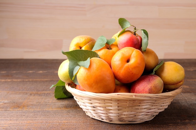 A lot of fresh, ripe apricot in a bag on a brown wooden table