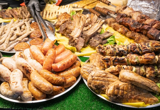 Lot of fresh street food at local fair market - bbq barbecue meat, ribs, sausages, chicken