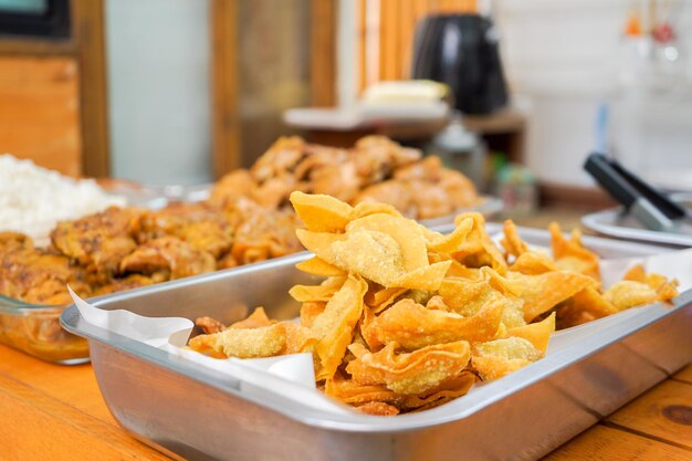 A lot of homemade Thai deep fried wonton in aluminum plate prepare for Asia noodle style