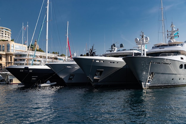 A lot of huge yachts are in port of monaco at sunny day monte carlo mountain is on background glossy...