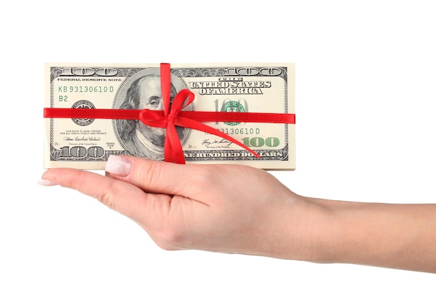 A lot of one hundred dollar bills tied red ribbon in hand isolated on white