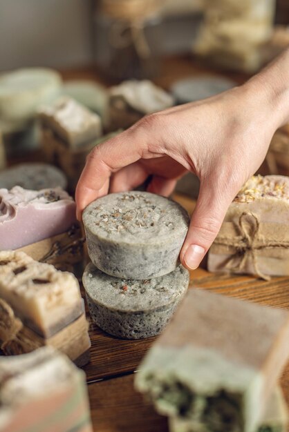 A lot of pieces of fragrant beautiful natural soap on a wooden table in the workshop