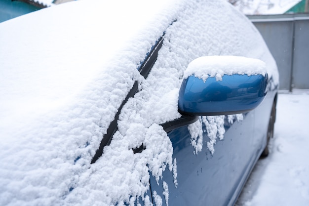 A lot of snow on a blue car close up