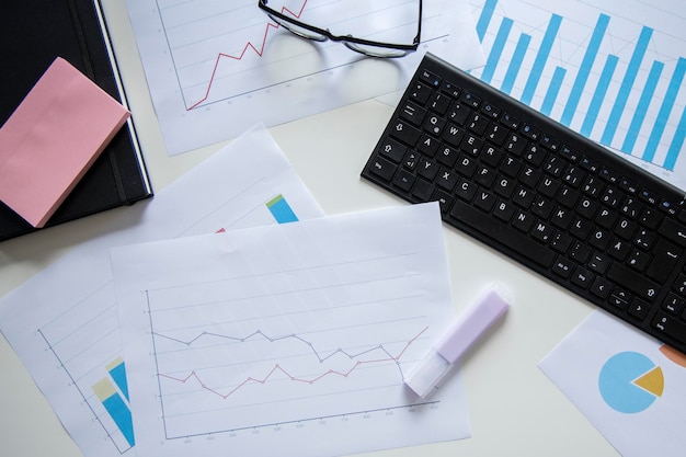 Photo lots of charts glasses on the desktop data collection and statistical work top view flat lay