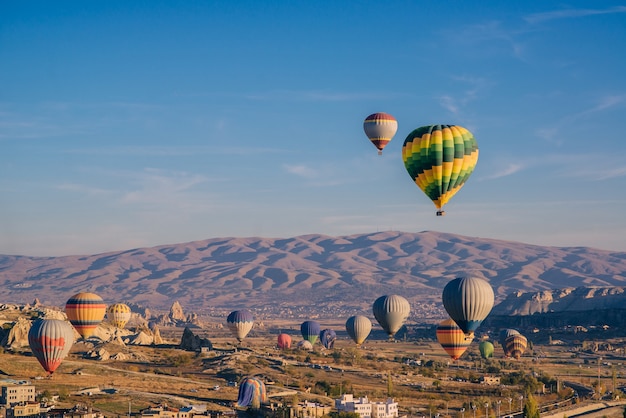 Lots colorful balloons in sky above mountains