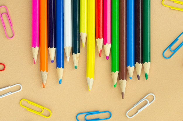 Lots of colorful pencils and paper clips, top view