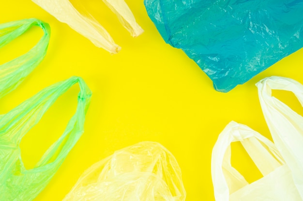 Lots of colorful plastic bags on yellow background