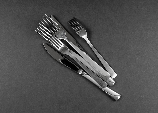 Lots of cutlery on black table abstract food background