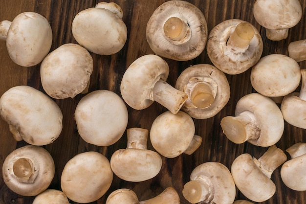 Lots of fresh champignons scattered on a wooden table