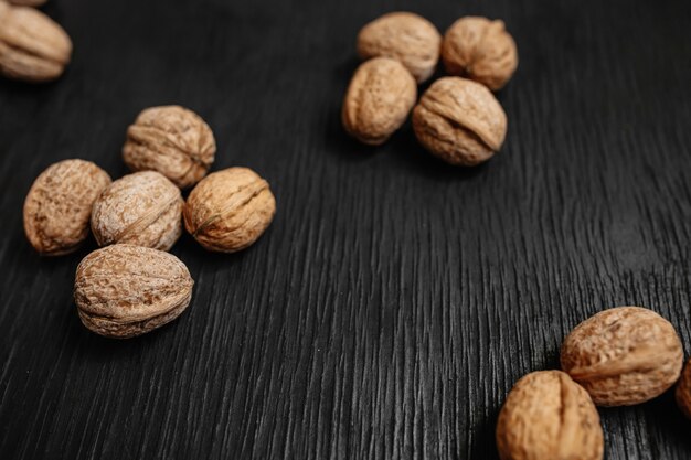 Lots of fresh nuts on a black wooden background. Best practices for designer. A beautiful design from the nuts