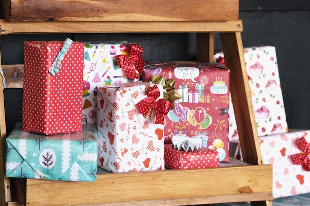 Lots of gift boxes put on a wooden shelf for Christmas.