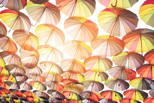 Lots of multi colored umbrellas umbrellas and sunlight bright palette of joy colors that cheer you up