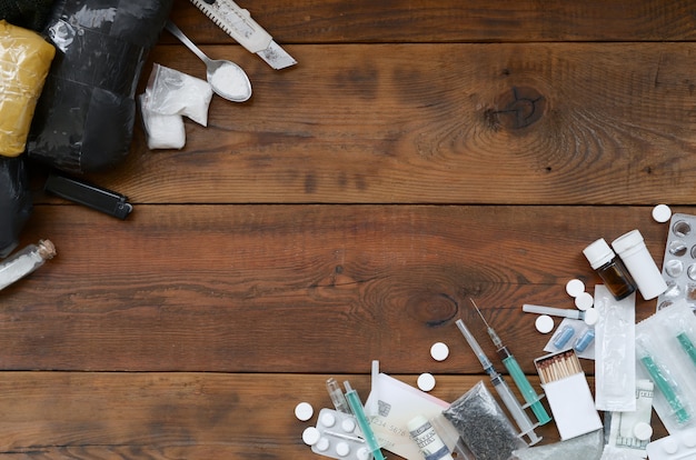 Lots of narcotic substances and devices for the preparation of drugs on an old wooden table