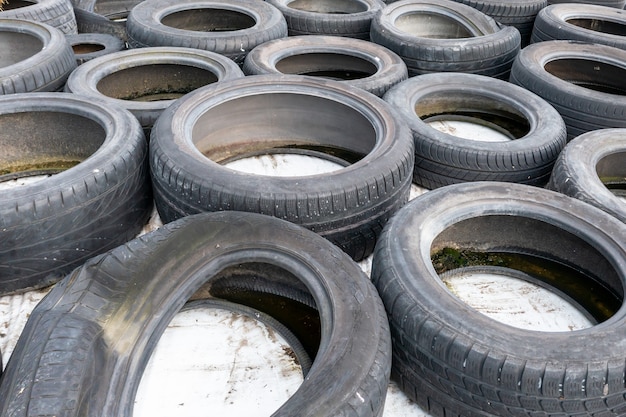 Lots of old used car tires close up on white background